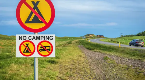 Schilder verbieten das Zelten und Wohnmobilfahren. Kein **island wildcampen** hier, nur eine Straße mit einem Auto.