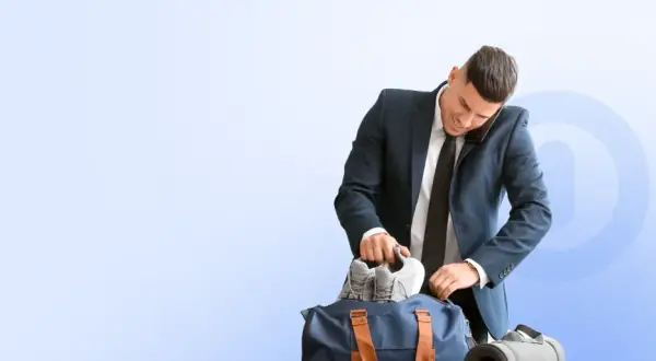Biznesmen pakuje buty do torby sportowej, zastanawiając się, co ile godzin można korzystać z Multisport Plus.