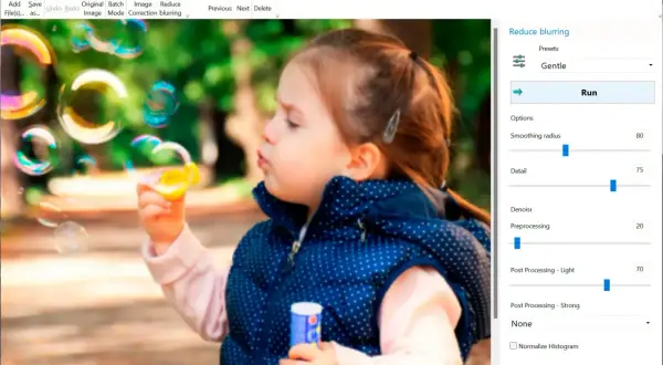 Program do wyostrzania zdjęć Easy Photo Unblur poprawia ostrość obrazu dziewczynki puszczającej bańki.