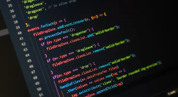 Fragment kodu JavaScript w programie do pisania, obsługujący zdarzenia przeciągania i upuszczania plików.