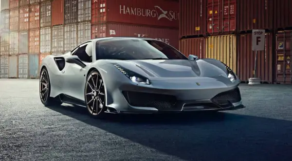 Srebrne Ferrari 488 Pista błyszczy na tle kontenerów portowych.