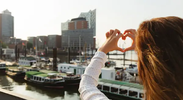 Herzförmige Geste vor Hamburgs Hafen. Ein toller Reisetipp Deutschland für alle, die maritime Städte lieben.