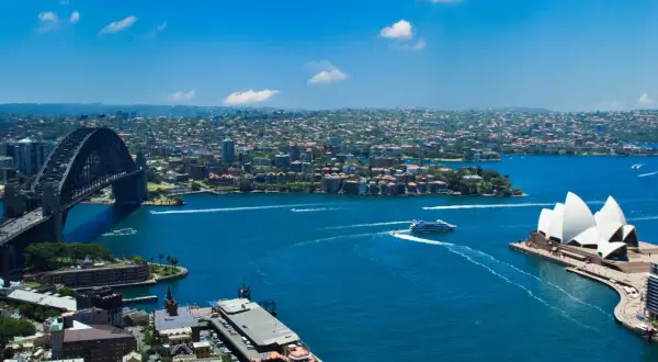 Widok na Zatokę Sydney z Operą i mostem Harbour Bridge. To właśnie Sydney, gdzie błękitna woda lśni w słońcu.