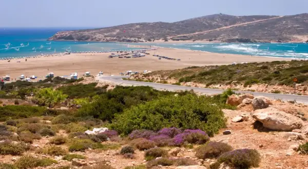 Piękna plaża na Rodos, idealne miejsce na windsurfing. W oddali widać góry, a droga prowadzi do tego rajskiego zakątka. Rodos miasto atrakcje to nie tylko zabytki, ale i takie widoki!