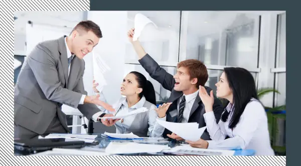 Business people in a meeting looking stressed and arguing, with papers flying.