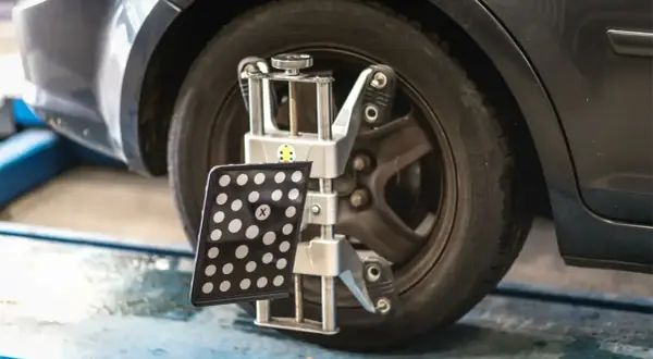 Appareil de mesure de géométrie de voiture fixé à une roue.