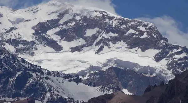 Aconcagua, najwyższy szczyt Ameryki Południowej, majestatycznie wznosi się w chmurach, pokryty śniegiem i lodem.