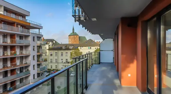 Widok z balkonu na nowoczesne bloki i zabytkowe kamienice w Kołobrzegu. Pilnie sprzedam mieszkanie w tej okolicy!
