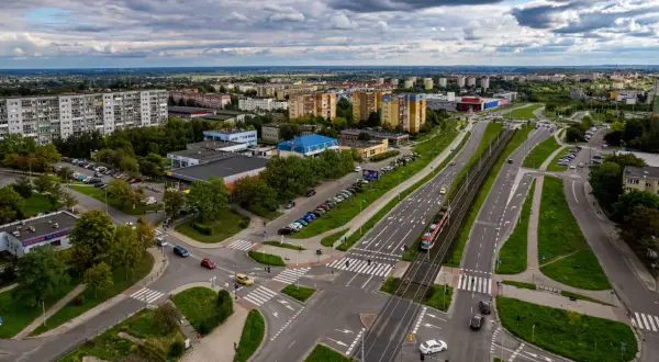 Widok z lotu ptaka na ruchliwe skrzyżowanie w Gdańsku Chełmie, z tramwajem i samochodami.