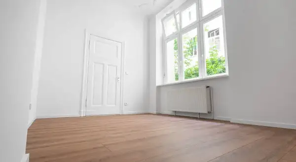 Puste, jasne pomieszczenie z drzwiami i oknem. Zastanawiasz się, ile się czeka na mieszkanie komunalne?
