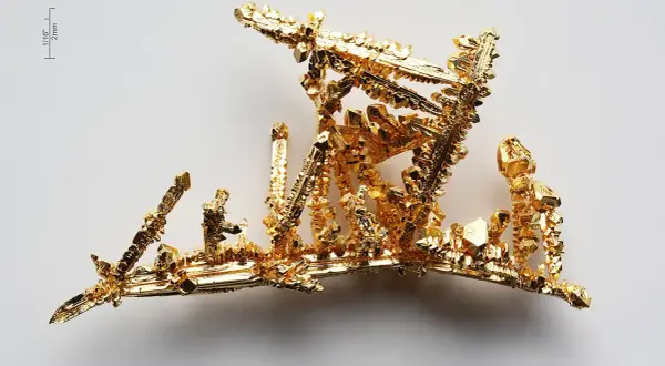 Złoto próba 525, krystaliczna struktura przypominająca miniaturowy, lśniący krajobraz.