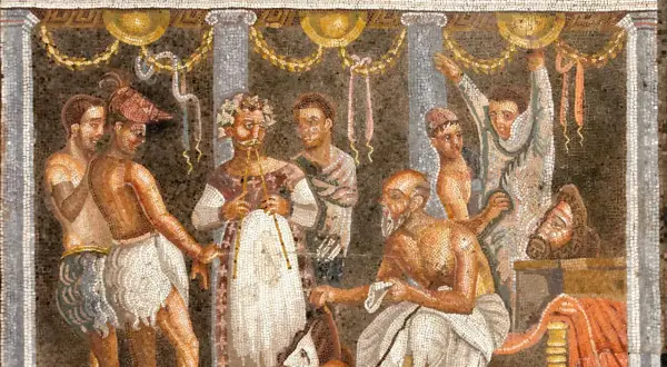 Starożytna mozaika: mężczyźni w togach, jeden z wieńcem laurowym, inny z brodą. Może to opowieść o tym, od czego pochodzi nazwa tragedia.