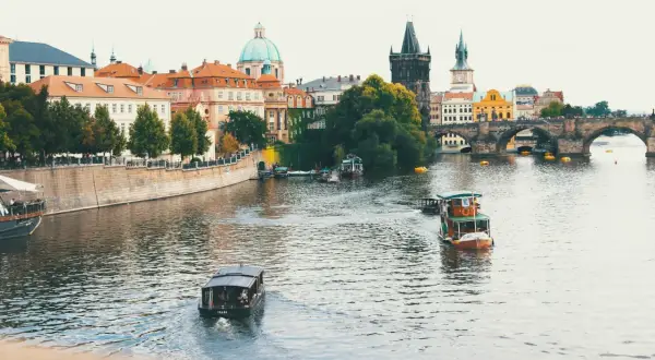Praga, Czechy. Widok na Wełtawę z łodziami i Mostem Karola. Ceny w Czechach mogą być zaskakująco przystępne, zwłaszcza poza sezonem.