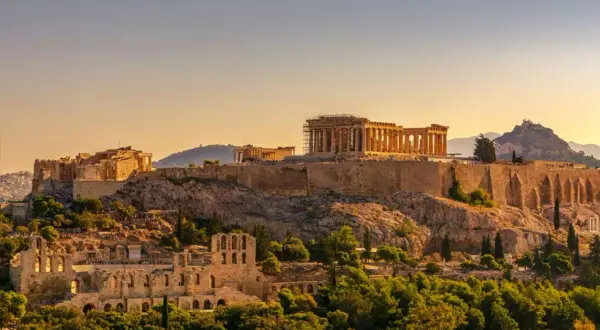 Akropolis reser sig majestätiskt på en kulle i Aten, med Parthenon i gyllene solljus.