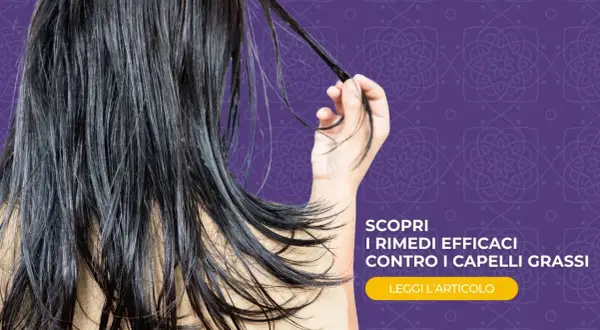 Capelli lunghi e scuri, che sembrano un po' appesantiti, con una mano che ne raccoglie una ciocca. Scopri rimedi efficaci contro i capelli grassi.