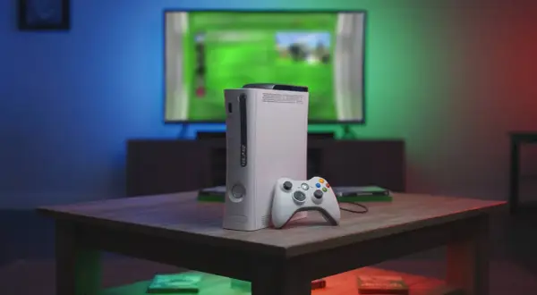 Biały Xbox 360 z kontrolerem na stoliku, przypominający czasy, kiedy wyszedł.