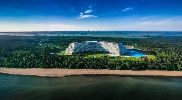 Nowoczesny hotel Gołębiewski w Pobierowie z basenem, otoczony lasem, nad morzem.