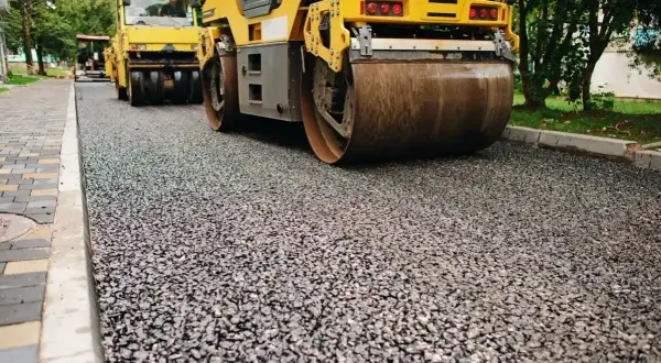 Walec drogowy ugniata świeżą nawierzchnię z kruszywa dolomitowego.
