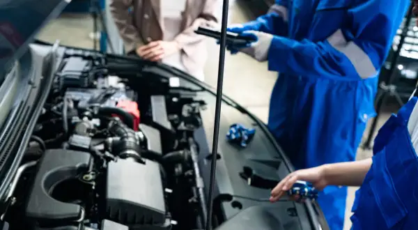 Mekanikerna diskuterar hur ofta ska man serva bilen medan motorhuven är öppen.
