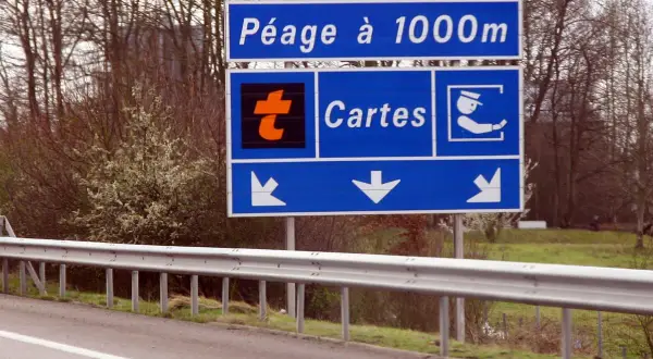 Panneau "Péage à 1000m" avec logo orange "t" et icône de carte. Indique dans quel sens mettre le badge télépéage Vinci.