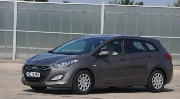 Szary Hyundai i30 II kombi, kierowca w zielonej koszulce. Zastanawiasz się, jakie żarówki do hyundai i30 ii wybrać?