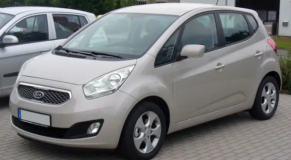 Jasny beżowy Kia Venga 1.4 benzyna stoi na kostce brukowej.