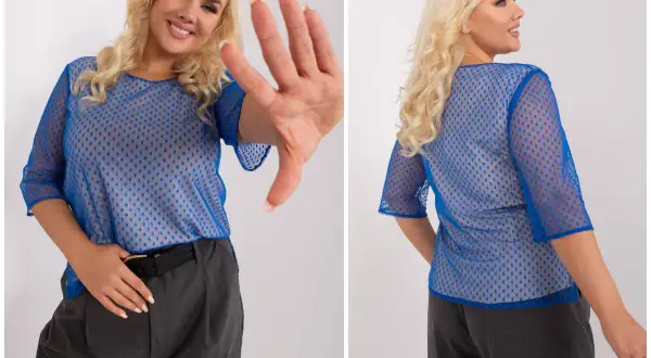 Uśmiechnięta kobieta w niebieskiej, ażurowej bluzce damskiej plus size w kropki, z rękami w geście "stop".