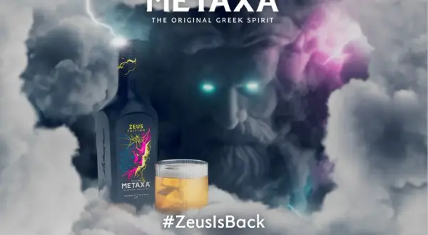Metaxa 12 cena. Zeus powraca! Butelka Metaxy Zeus Edition i szklanka z bursztynowym trunkiem na tle burzy i twarzy Zeusa.
