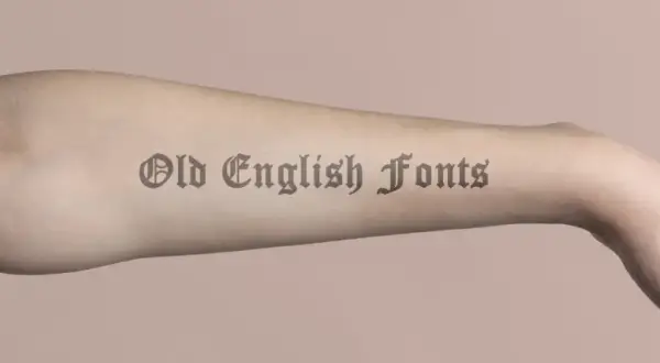 Ein Arm mit einem Tattoo-Schriftzug in Old English Fonts.