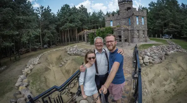 Rodzina pozuje do selfie przed kamiennym zamkiem, odkrywając nietypowe atrakcje Podlasia.