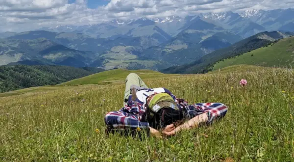 Odpoczynek na łące w Tuszetii, Gruzja. W tle majestatyczne góry Kaukazu.