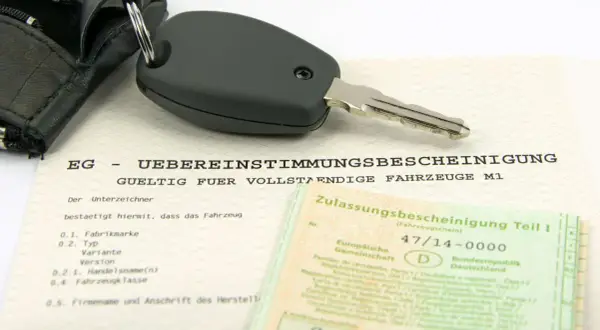Clé de voiture sur un certificat de conformité européen. Ce document atteste de la conformité d'un véhicule, essentiel pour l'immatriculation, y compris pour les poids lourds.