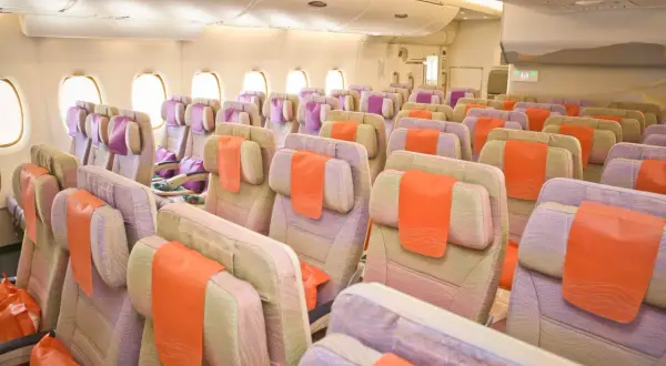 Leere Kabine mit bunten Sitzen, bereit für Passagiere. Eine gute Emirates Airlines Bewertung ist bei diesem Anblick zu erwarten.