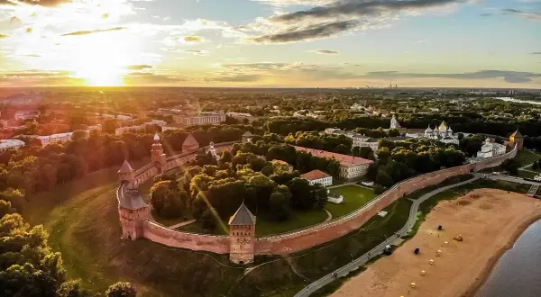 Solnedgång över Novgorod, en historisk stad med en imponerande kreml. Denna vy liknar en gammal **Novgorod karta** med sina befästningar och gyllene kupoler.