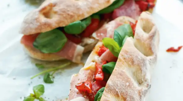 Två läckra panini med prosciutto, tomater och basilika. Ett perfekt panini recept för en snabb och smakrik lunch.