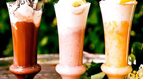 Tre läckra milkshakes i glas med grädde och strössel. Perfekt för ett somrigt milkshake recept!