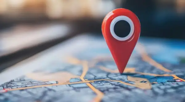 Czerwony pin na mapie cyfrowej symbolizuje punkt na trasie, przypominając o historii lokalizacji Google.
