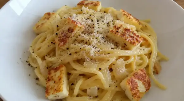 En krämig vegetarisk carbonara med spaghetti, stekt halloumi och rikligt med parmesanost och svartpeppar.