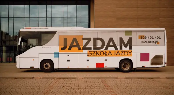 Biały autokar z napisem "JAZDAM SZKOŁA JAZDY" i numerem telefonu. Idealny do nauki jazdy kategorii D.