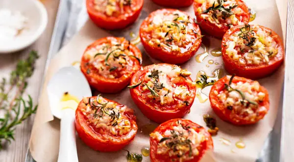 Tomates provençales garnies d'herbes et de fromage, rôties sur une plaque. Un délice parfumé !
