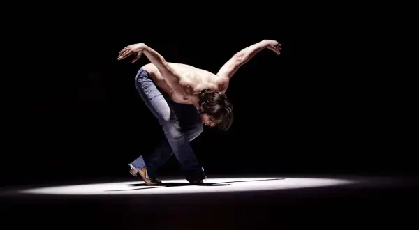 Joaquín Cortés flamenco, un torbellino de pasión y arte, se mueve con fuerza en el escenario.