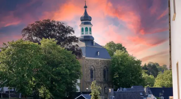 Kirchturm in Solingen Altstadt vor dramatischem Abendhimmel.