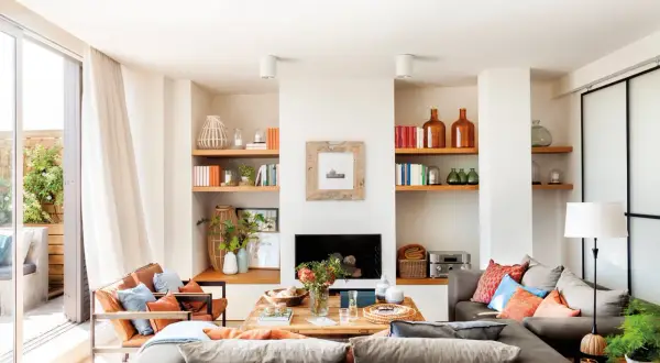 Ideas para un salón comedor acogedor con sofás grises, sillones de cuero, chimenea y estanterías llenas de libros y objetos decorativos.