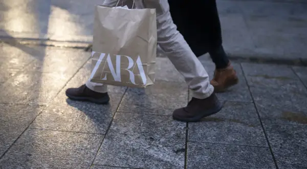 Osoba idzie z torbą z logo ZARA. Może to być efekt zakupów zrobionych przez aplikację ZARA.