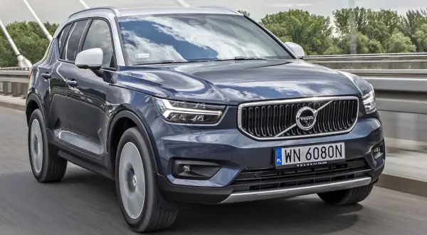 Ciemnoszary Volvo XC40 jedzie po moście. Sprawdź aktualną volvo xc40 cena i dostępne wersje.