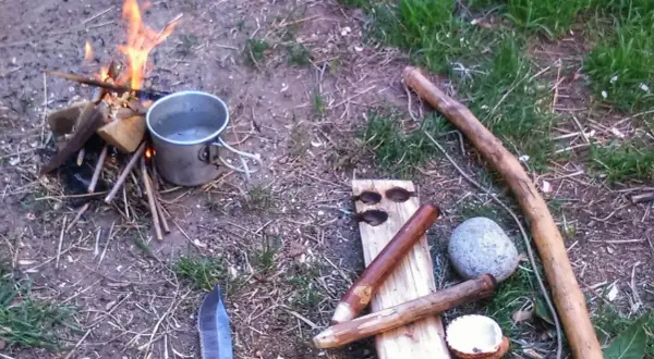 Un cuchillo, un cazo y leña para prender fuego. Preparativos para una noche al aire libre.