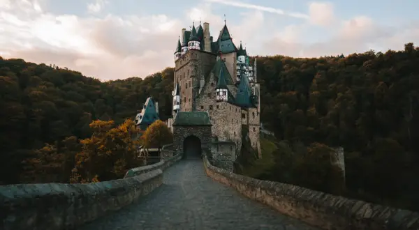 Kamienny most prowadzi do bajkowego zamku Eltz, jednego z najpiękniejszych zamków w Niemczech, otoczonego jesiennym lasem.