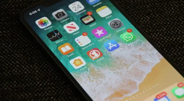Ekran iPhone'a z ikonami aplikacji. Dowiedz się, jak zmniejszyć czułość ekranu dotykowego, aby uniknąć przypadkowych dotknięć.