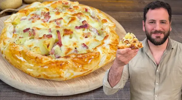 Una golosa torta salata patate e speck, con un uomo che ne mostra una fetta invitante.