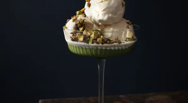 Krämig pistageglass i ett elegant glas, toppad med krossade pistagenötter. Ett perfekt pistageglass recept för en lyxig dessert.